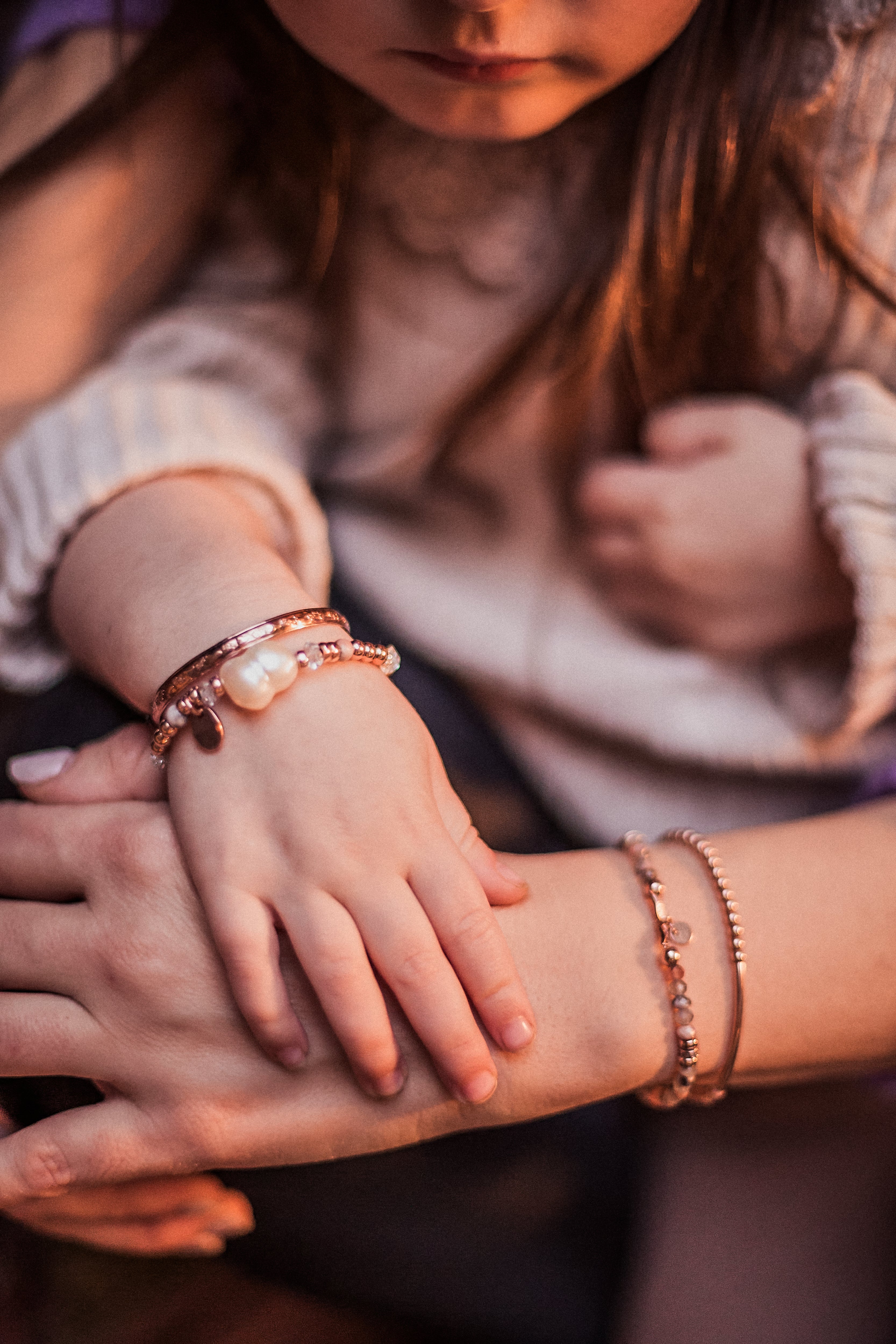 Mother and toddler wearing matching rose gold bangles and beaded pearl and Herkimer diamond bracelets, embodying the transformation from darkness to light. Inspired by the brand story of Melana, symbolizing personal growth, enlightenment, and the radiant journey of motherhood. Handcrafted jewelry that celebrates life’s profound changes and connections.