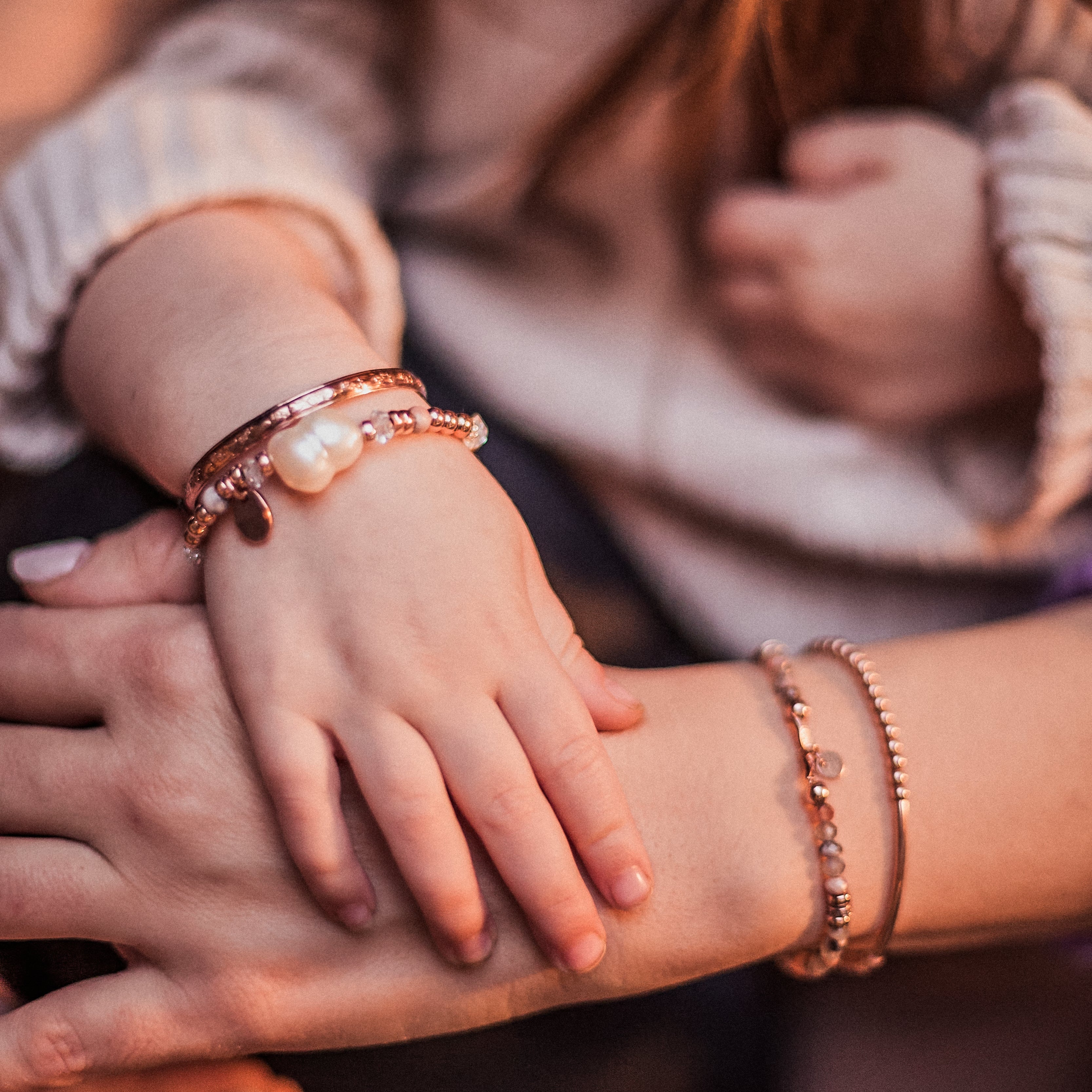 Mother and toddler wearing matching rose gold bangles and beaded pearl and Herkimer diamond bracelets, embodying the transformation from darkness to light. Inspired by the brand story of Melana, symbolizing personal growth, enlightenment, and the radiant journey of motherhood. Handcrafted jewelry that celebrates life’s profound changes and connections.