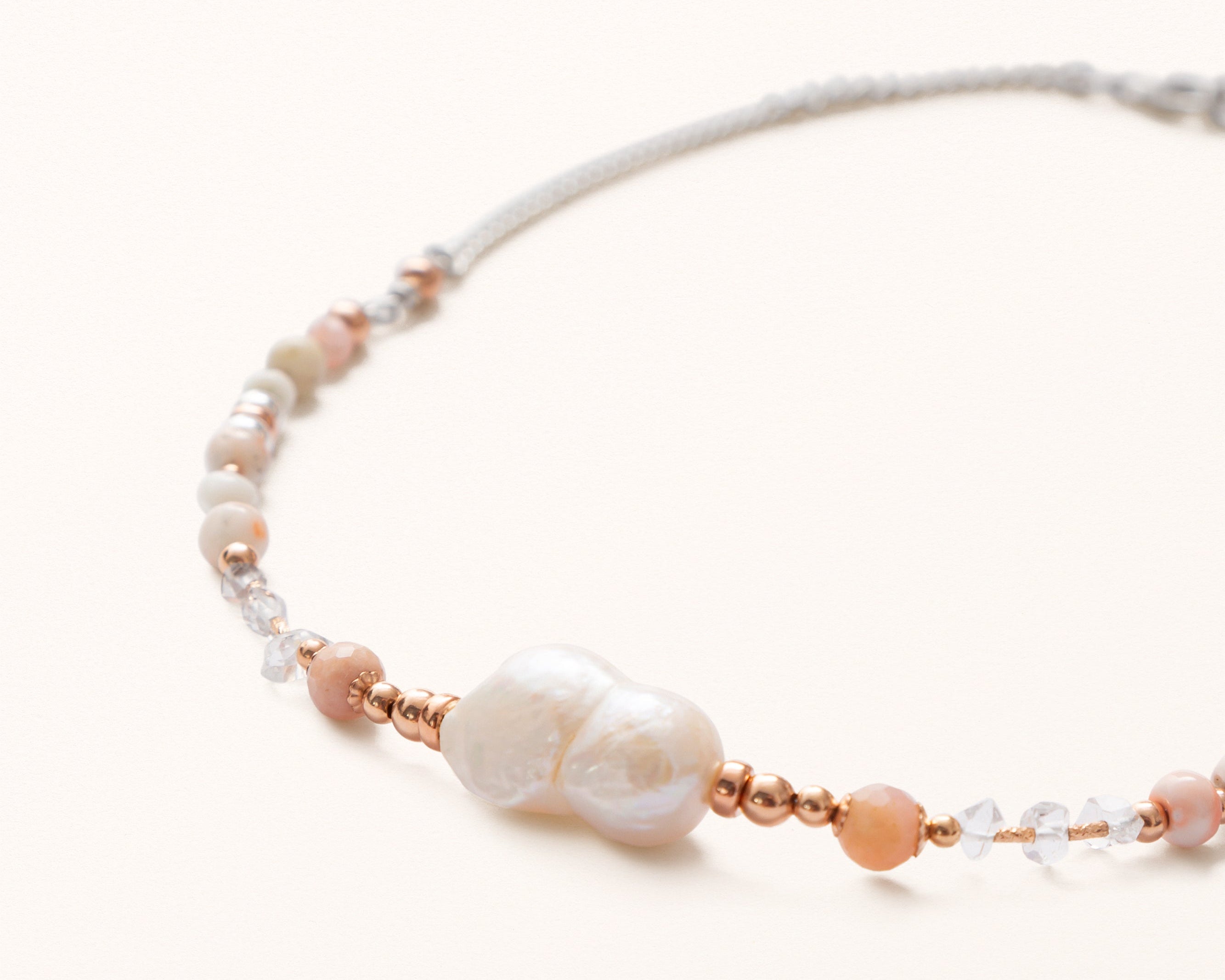 Pearl Necklace with white and rose gold beads on a white background.